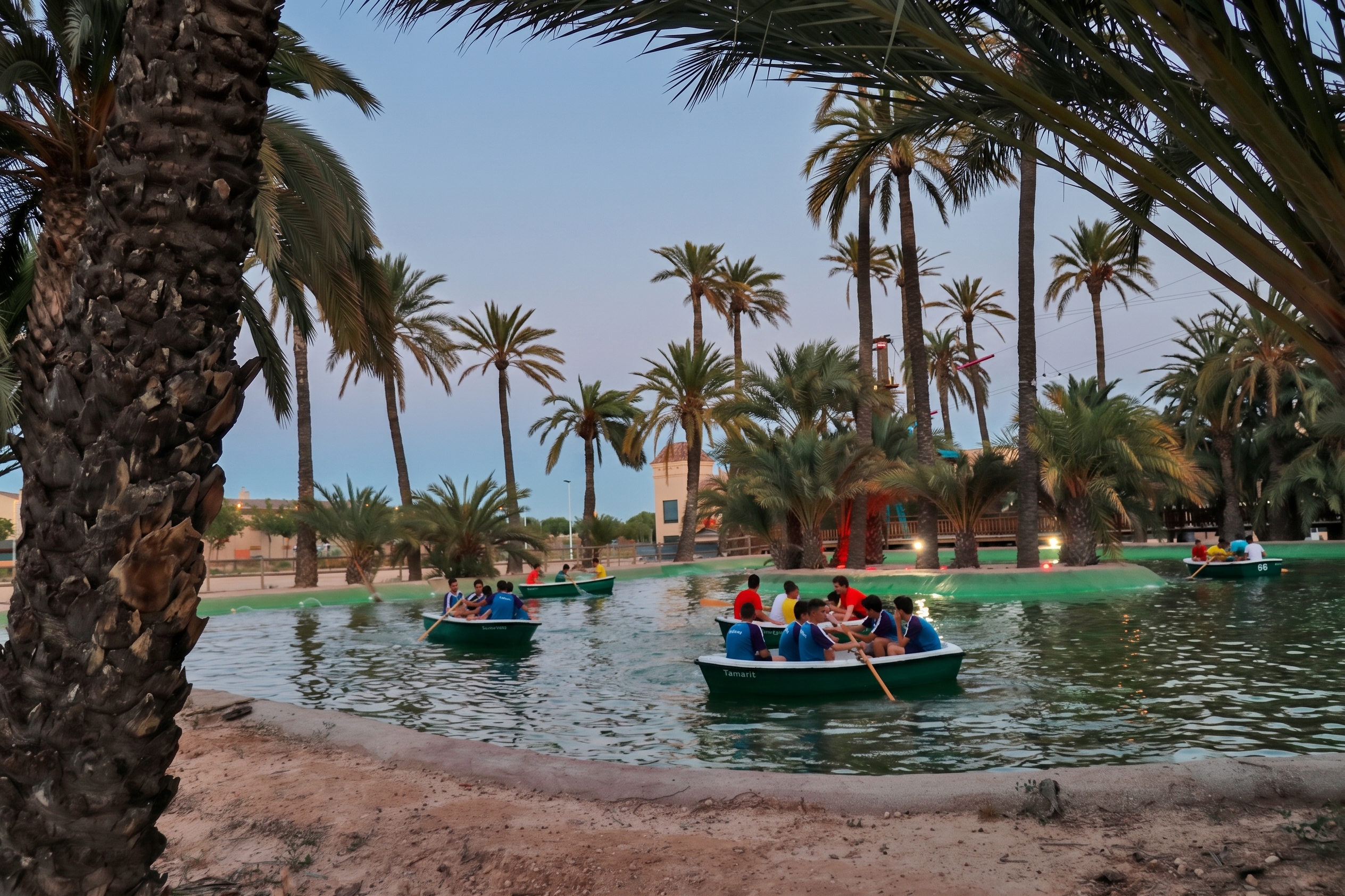 Niños navegando en barcas por el lago del parque multiaventura de Elche