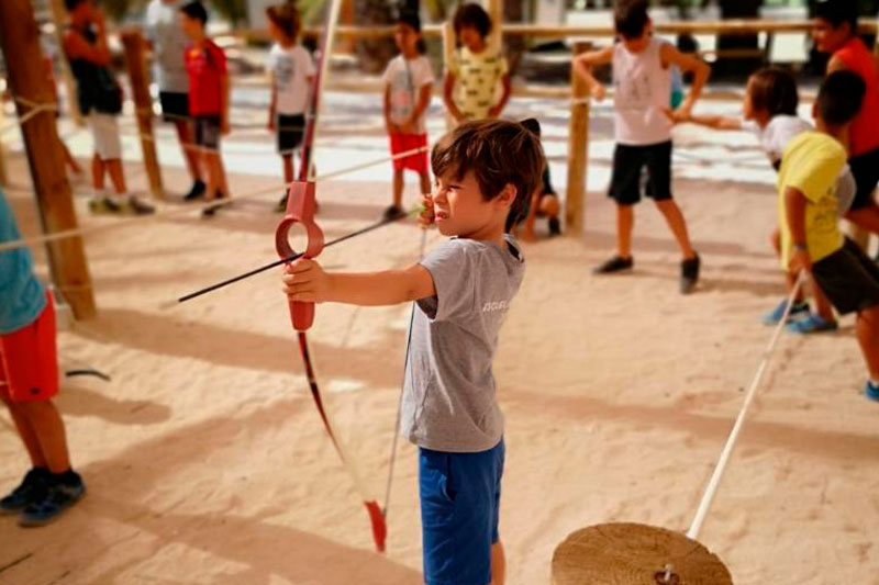 Niños practicando tiro con arco en el parque multiaventura de Elche