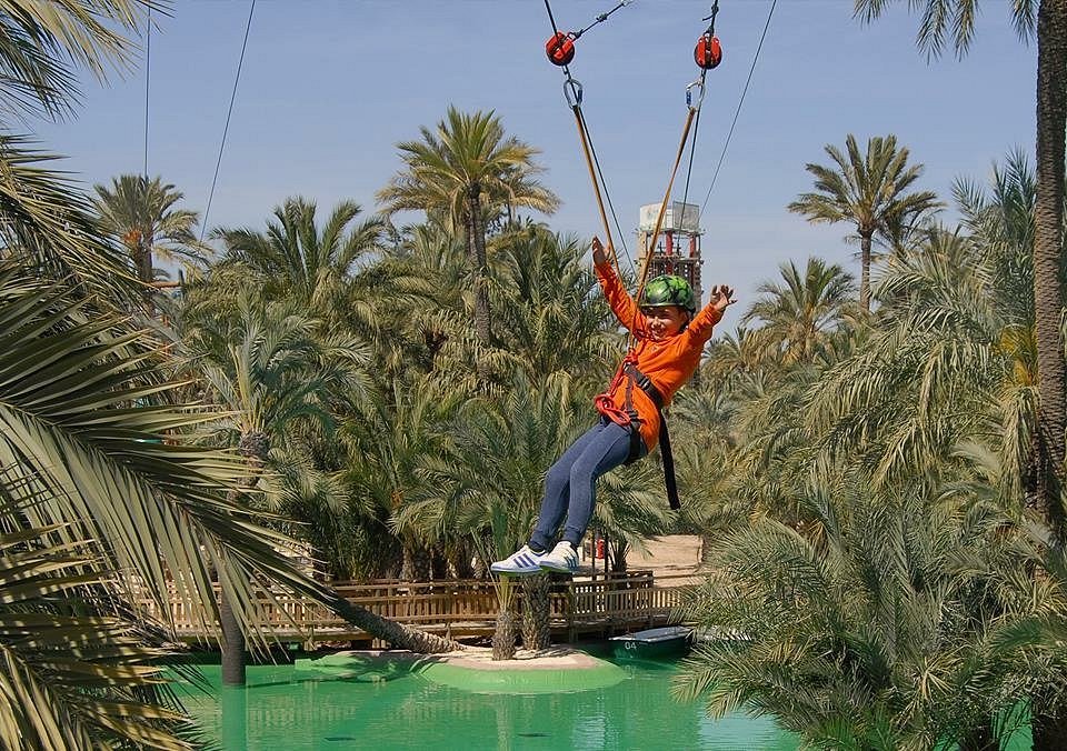 Niña lanzándose por la tirolina gigante del parque multiaventura de Elche